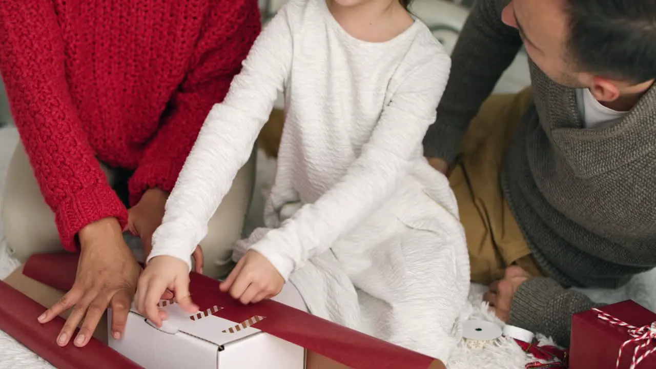 Handheld view of family packing Christmas gifts