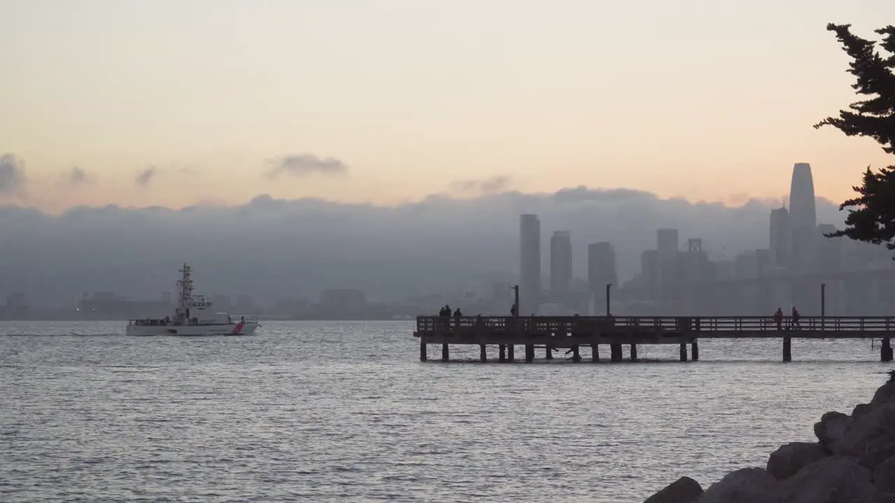 US Coast Guard Boat Sails Past a Fishing Pier With San Francisco in the Background