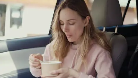 Woman having her meal inside the parked car