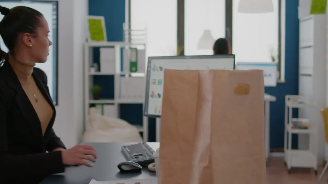 Businesswoman holding delivery takeaway food meal order paper bag during takeout lunchtime