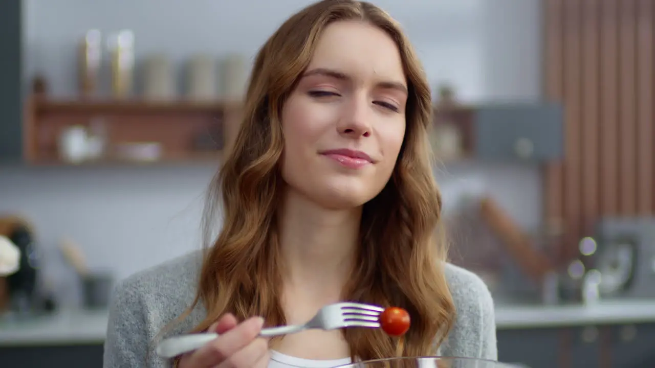 Portrait of smiling woman eating fresh salad at home kitchen Vegetarian food