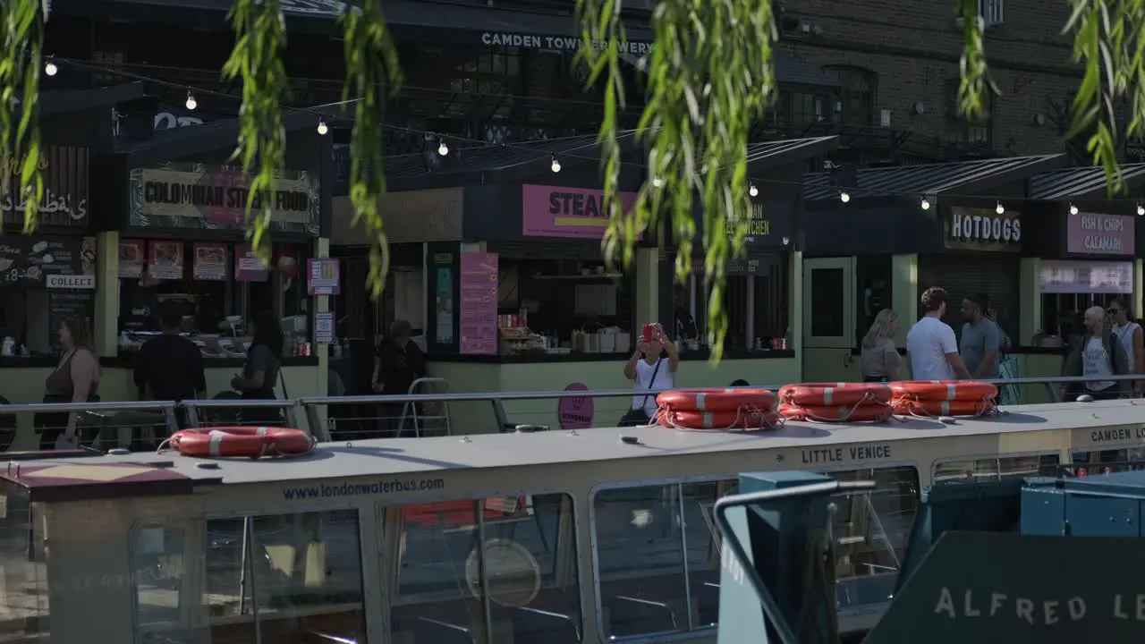 People Passing By Food Stalls At The Camden Lock Market In London England