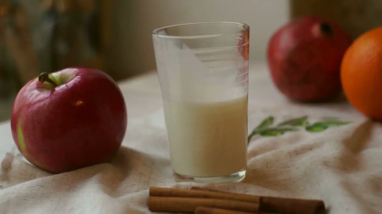 Glass of milk with red apple and orange on tablecloth Breakfast food