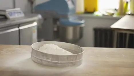 Close up hands putting flour in a sieve at the kithen Indoor slow motion