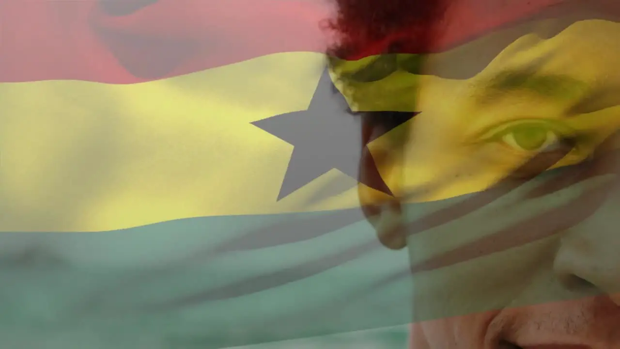 Animation of flag of ghana over african american man at beach