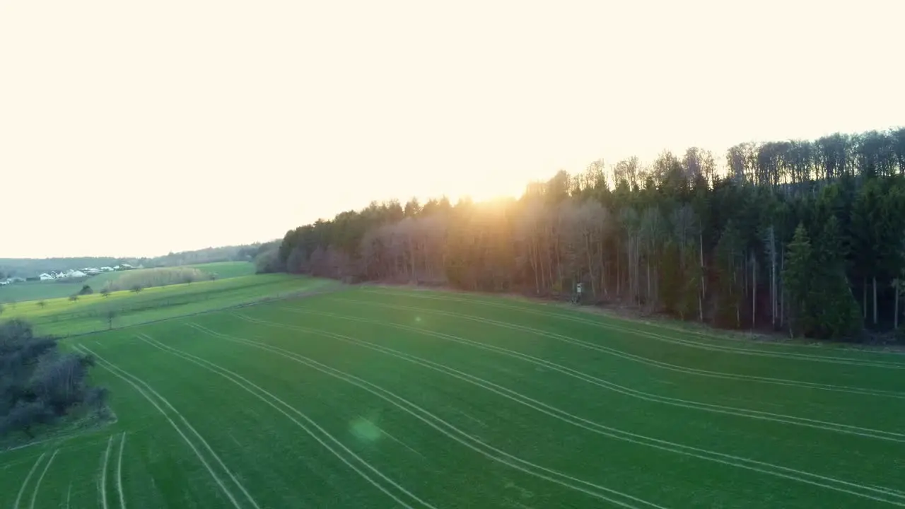 Panning view from sky over agricultural field and small town during sunrise in Germany