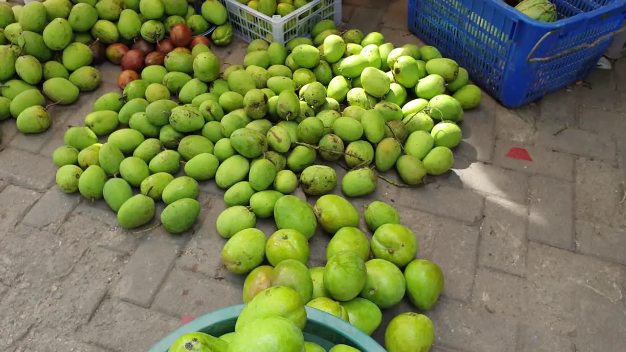 Hundreds of freshly picked delicious green mangoes at local fruit and vegetable produce market in capital city Dili Timor Leste in Southeast Asia