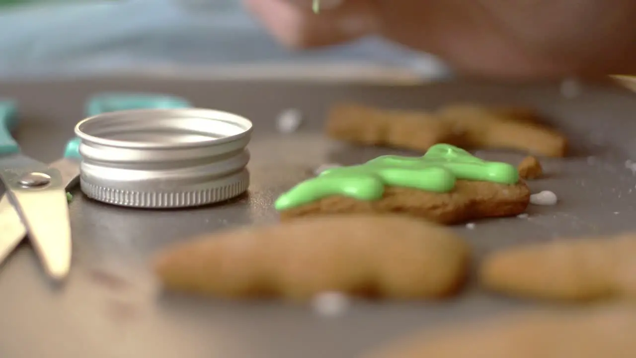 Decorating gingerbread Christmas cookies with sugar icing and candies close up isolated shot 4k