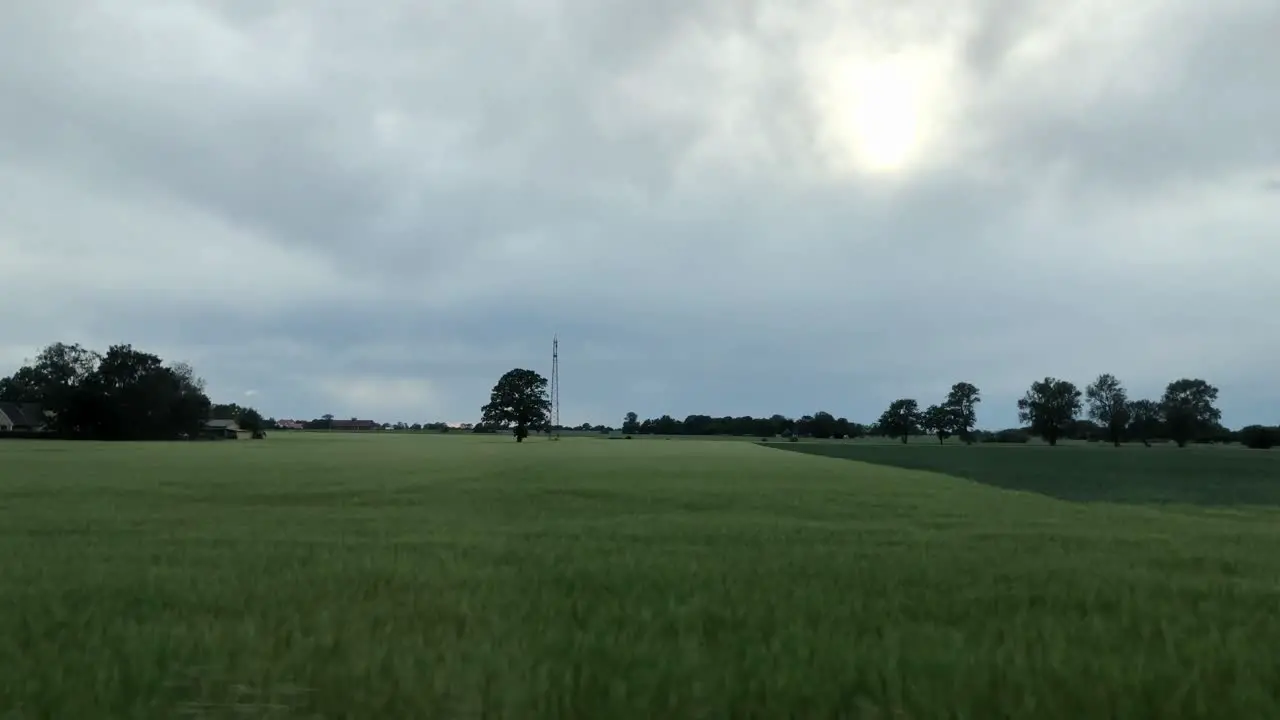 Drive by the green fields during a storm