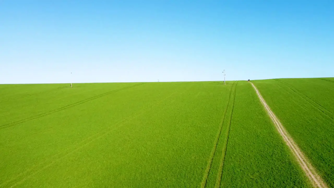 Flying over a bright green field with a footpath in the middle