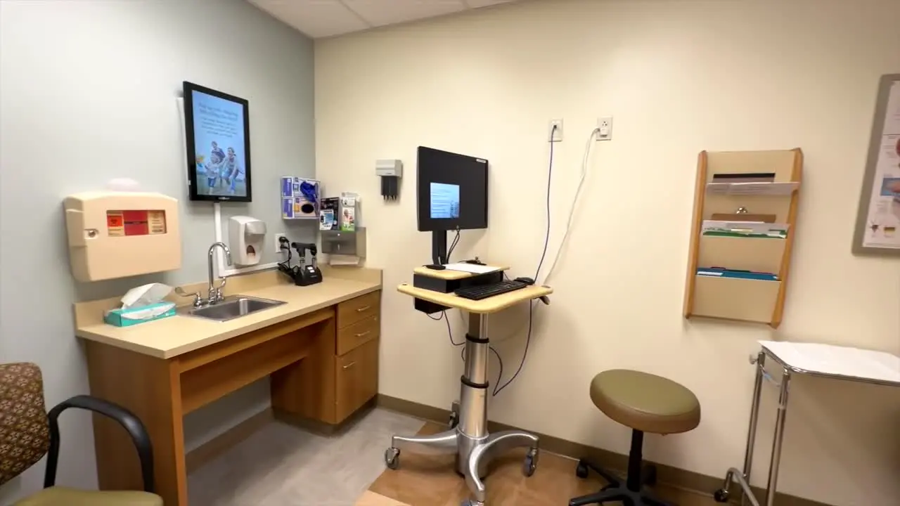 Empty doctors office panning the room showing medical items computer and tray