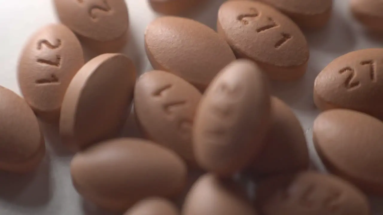 Brown Oval Pills Falling And Scattered On Top Of A White Table