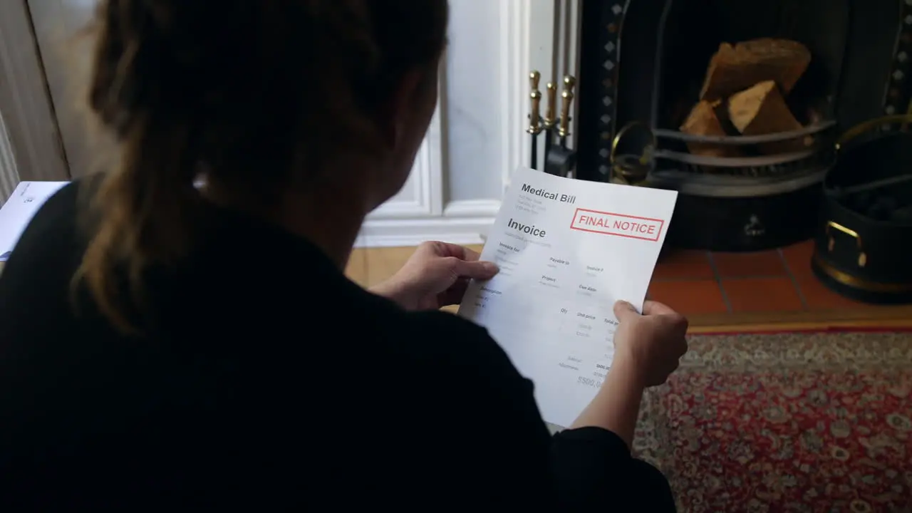 An unrecognizable female opening a debt letter