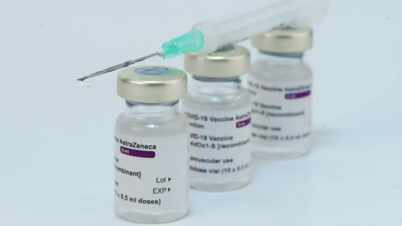 Syringe with needle over AstraZeneca covid-19 vaccine ampoules