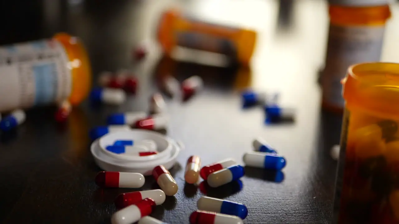 A prescription pharmacy medicine bottle full of pills falling in slow motion