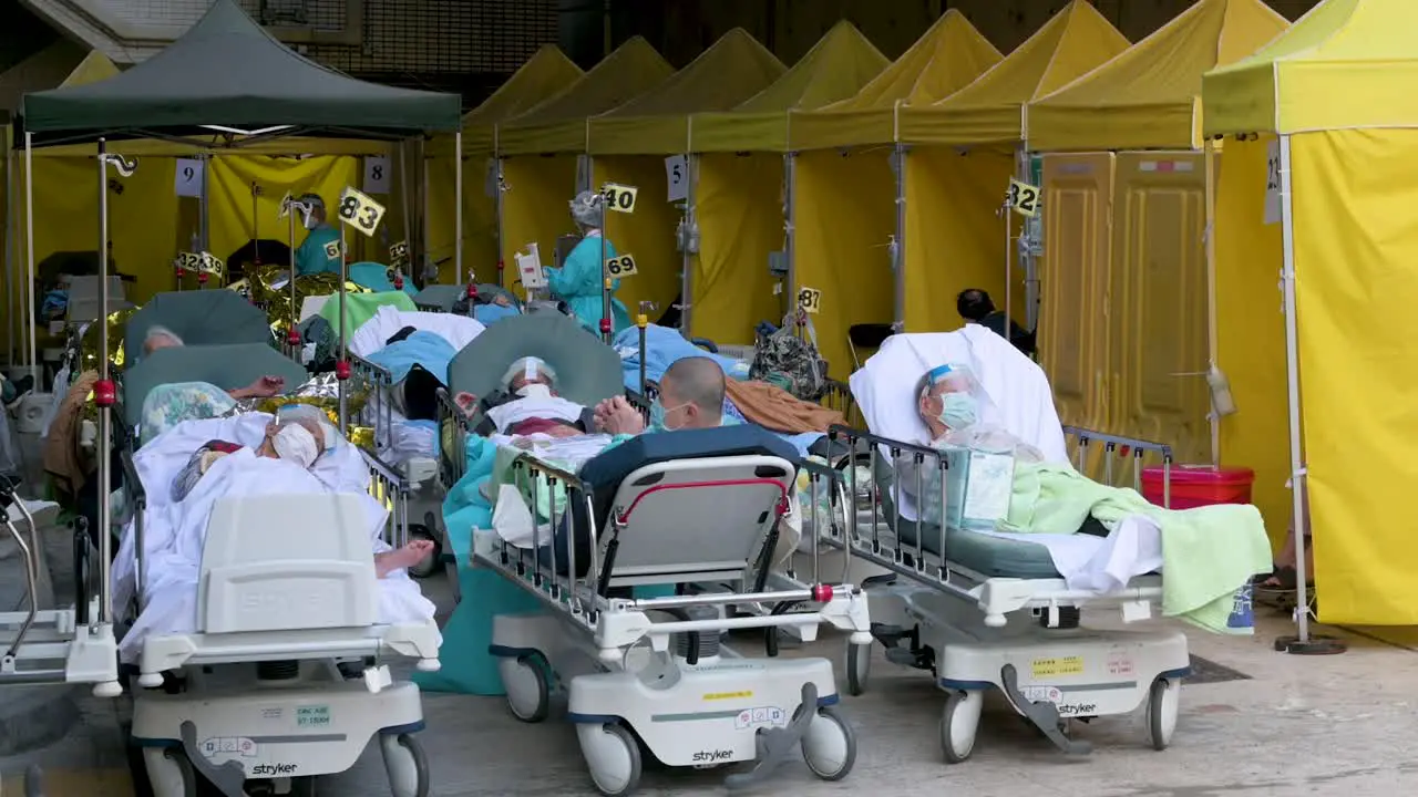 Patients with Covid-19 symptoms rest as they lie in beds outside an overcrowded hospital while the medical system collapses with hospitalizations