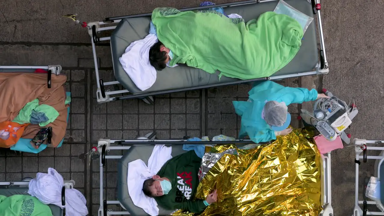 Chinese patients with Covid-19 symptoms lie in beds as they are being treated outside an overcrowded hospital while the medical system collapses with hospitalizations