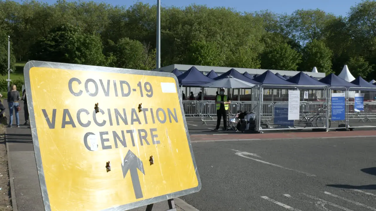 Entrance to a COVID-19 vaccination centre with people queueing for their coronavirus vaccine