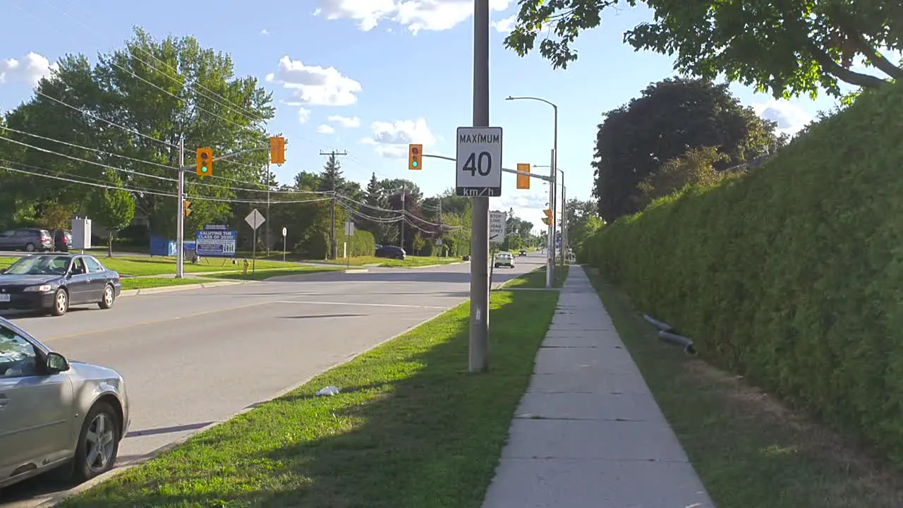 Paramedics in car with lights on driving quickly down a residential street in a city on a sunny summer day