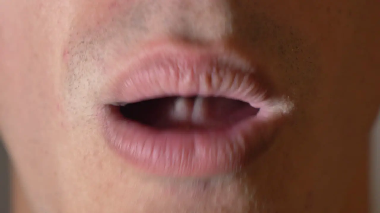 Extreme close-up mouth of a Youngman coughing