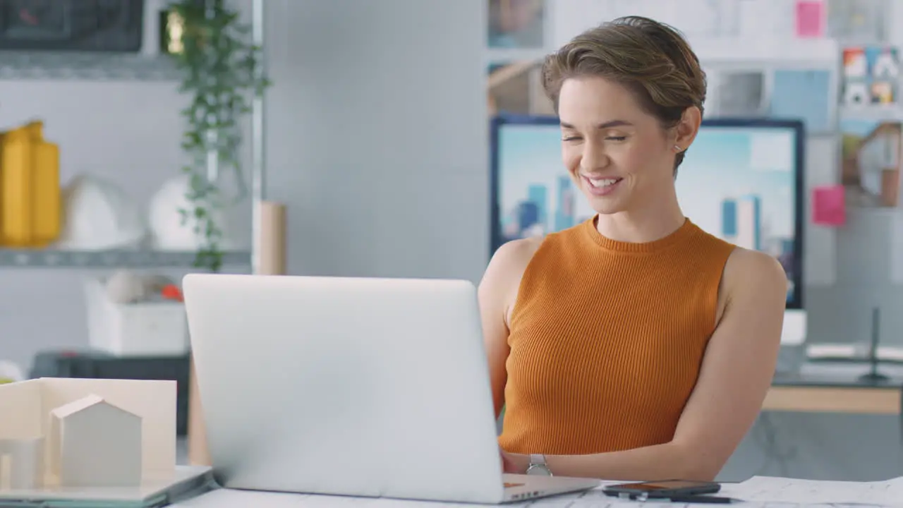 Female Architect In Office Making Video Call At Desk On Laptop