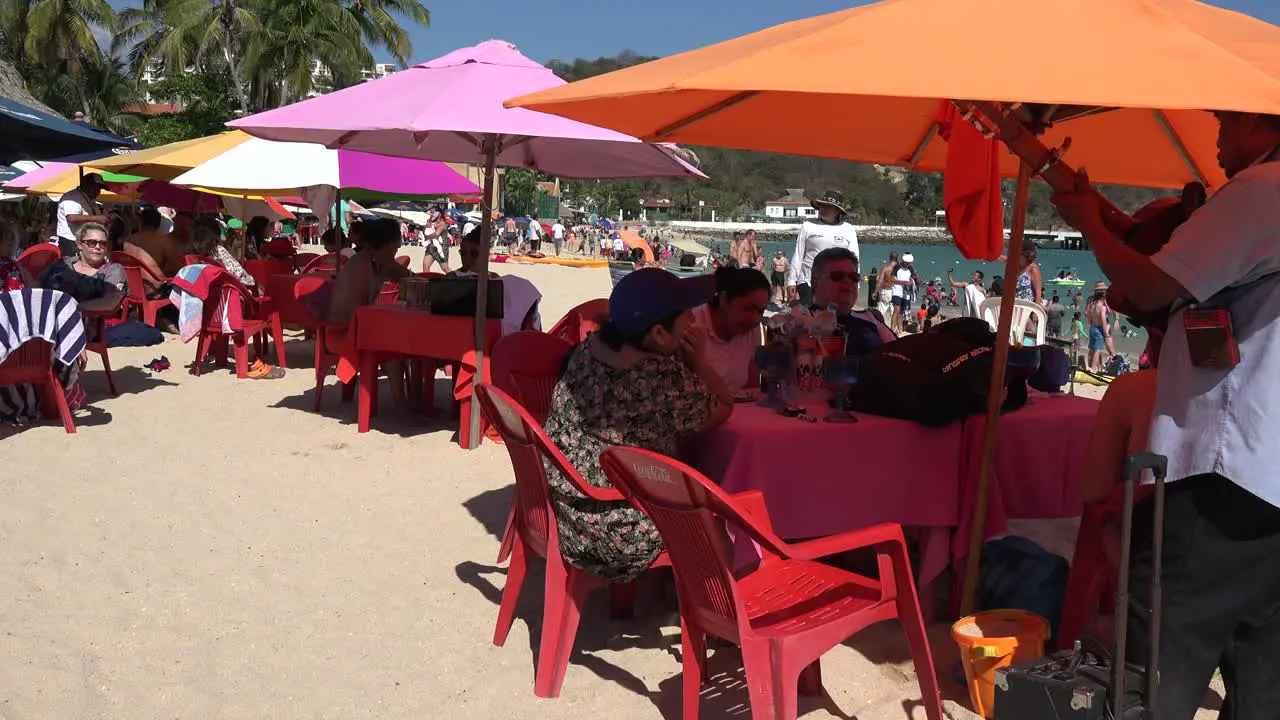 Mexico Huatulco people under umbrellas