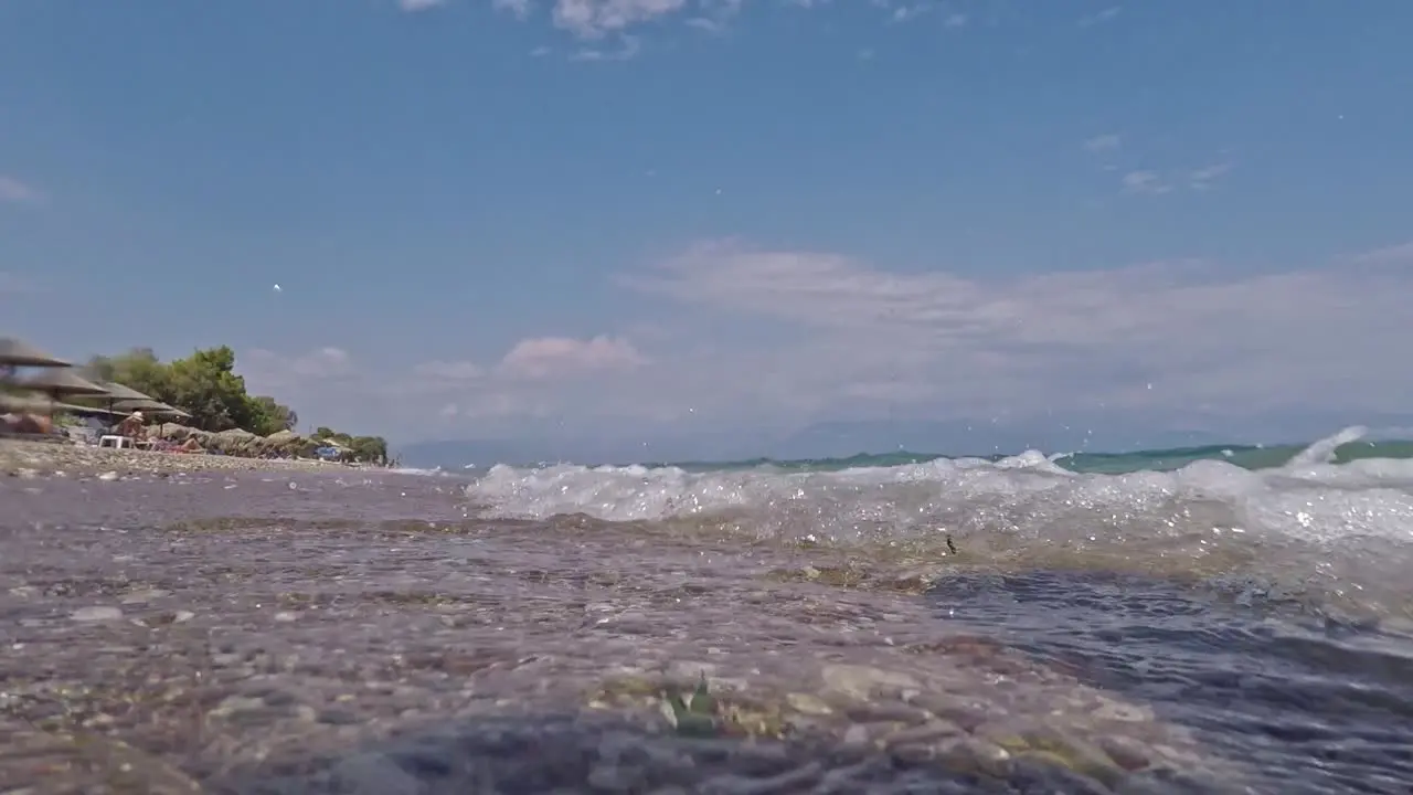 Low ground view of waves hitting the seashore at Chrani beach Messinia Peloponnese  Greece 60fps