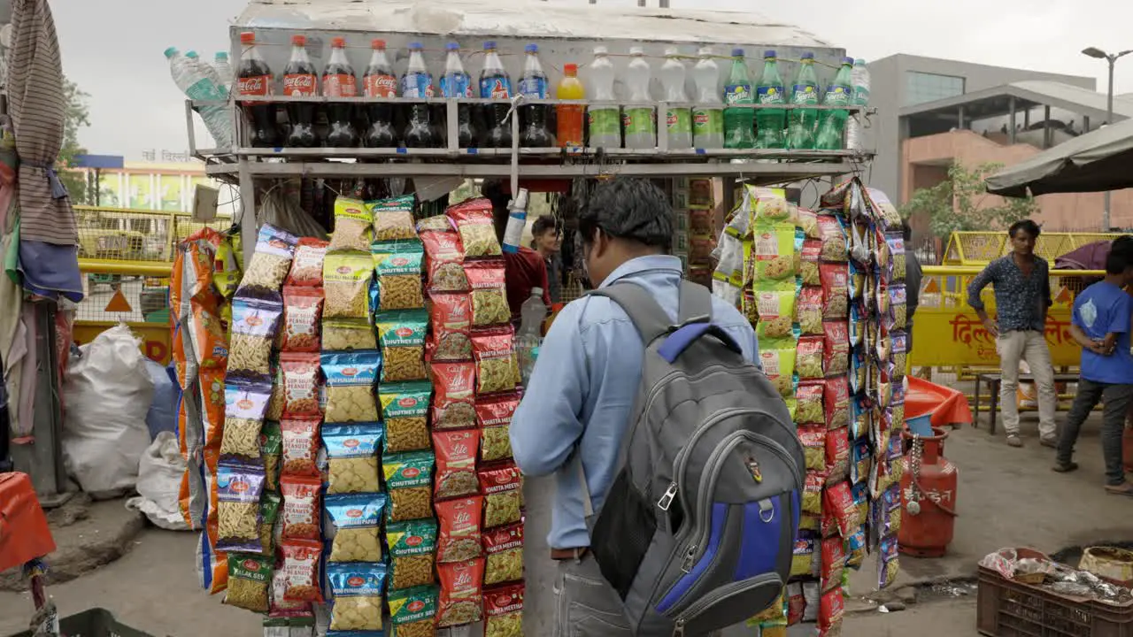 Man buying snacks at street shop Delhi India