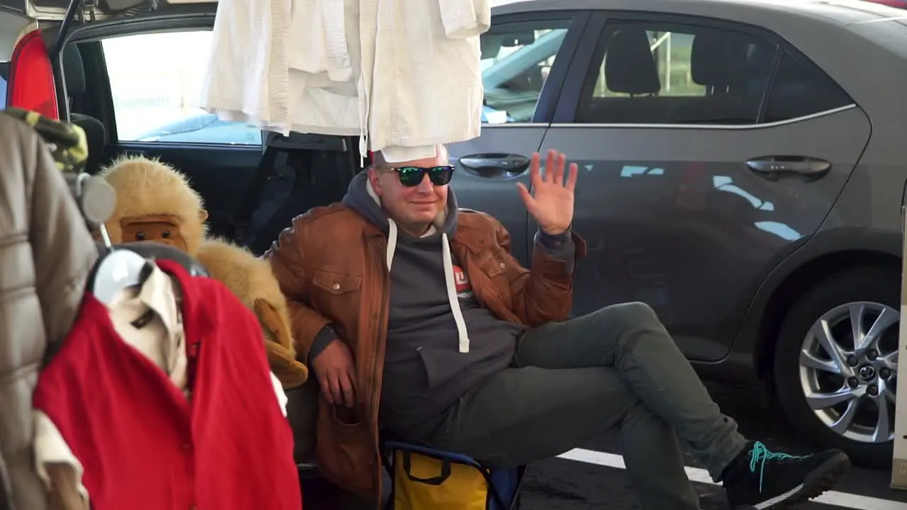 Man waving with monkey toy from the car