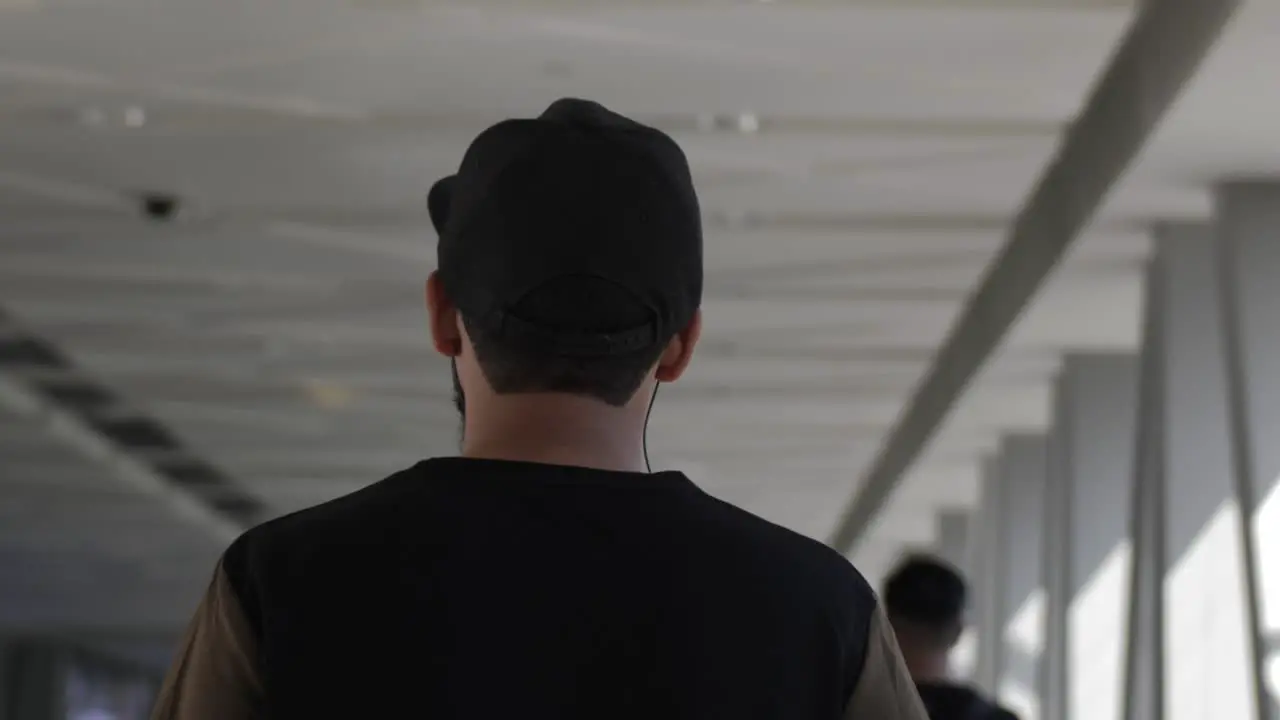 A man wearing a hat walking in slow motion at the Dubai shopping mall in the United Arab Emirates