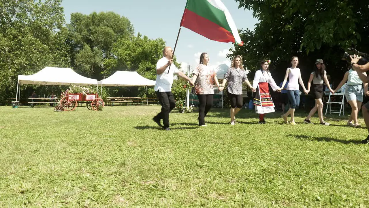 Village mayor waves national flag and dances with crowd at cultural event