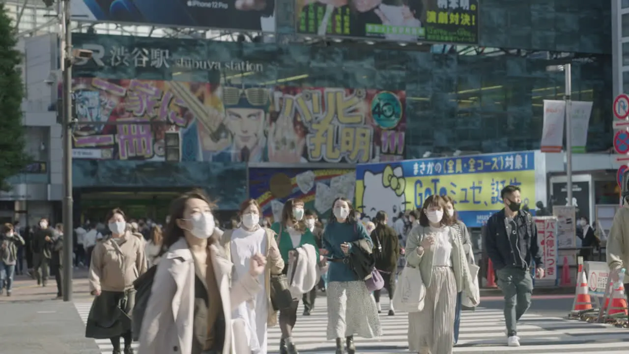 Young Japanese Women Walking Across The Famous Shibuya Crossing With Go Signal Light At Background In Tokyo Japan