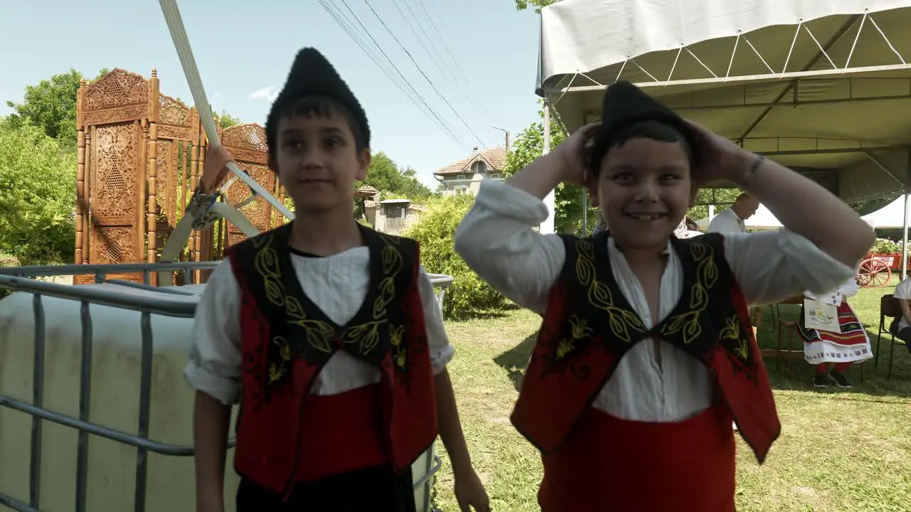 Two happy smiling boys in traditional Bulgarian dress and kalpak hats