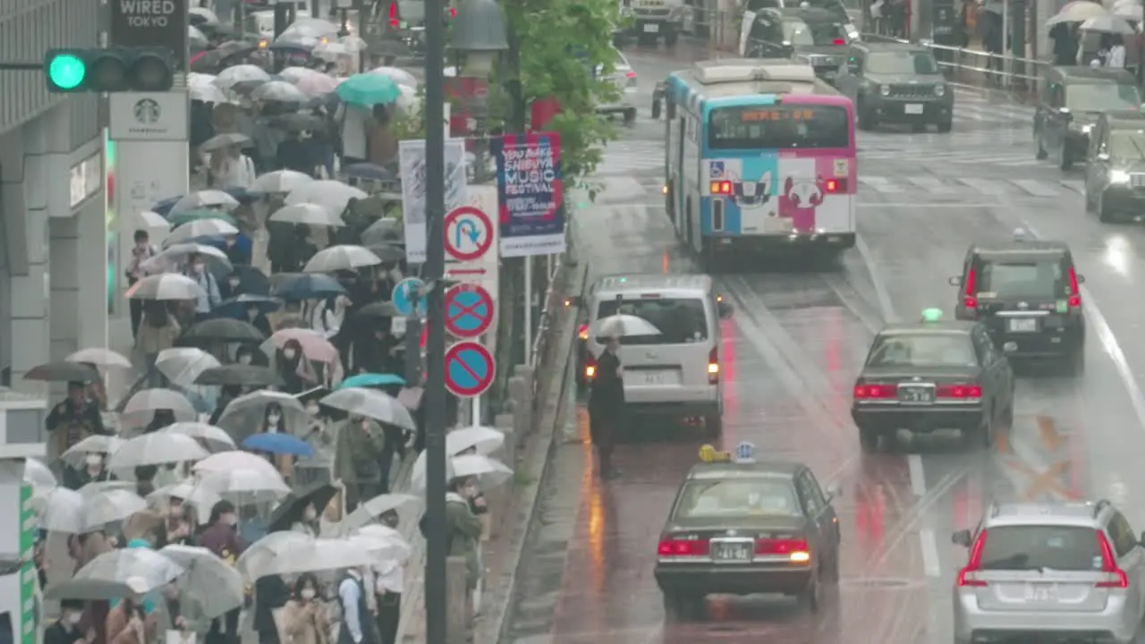 Crowd With Umbrellas Walking On Sidewalk Street Near Shibuya Crossing In Tokyo Japan During Rainy Day