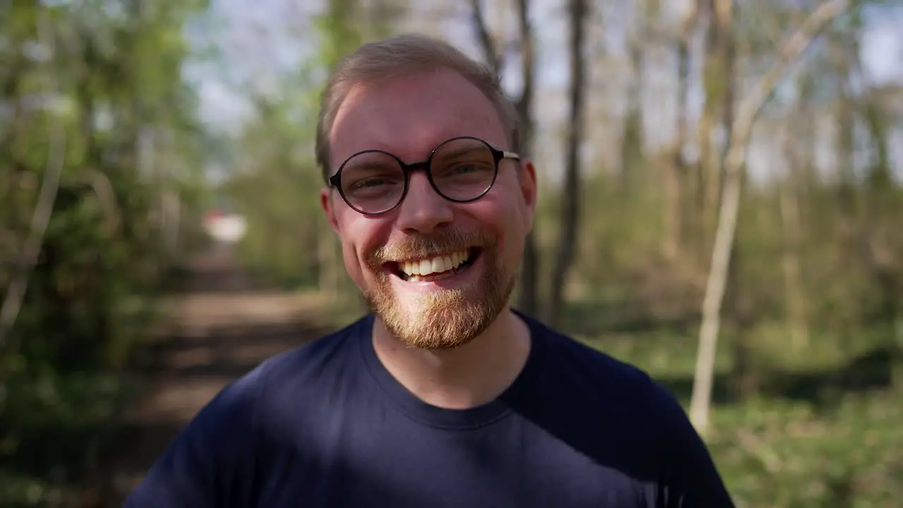 Excited Handsome Caucasian Man with Glasses Laughing Close Up in Nature