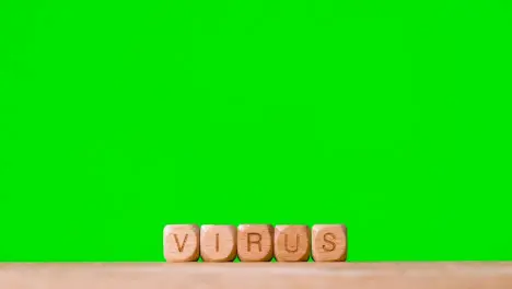 Medical Concept With Wooden Letter Cubes Or Dice Spelling Virus Against Green Screen Background