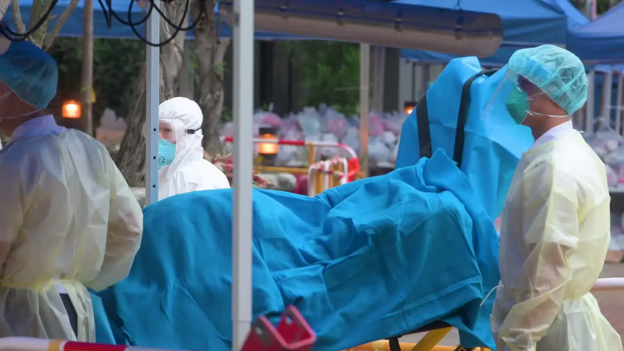 Health workers carry a stretcher outside a residential building placed under lockdown after a large number of residents tested positive in Hong Kong