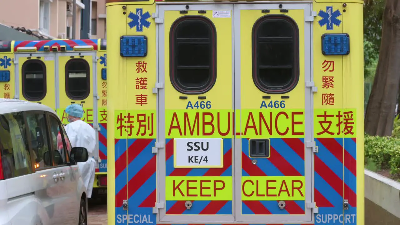 Health workers carry a medical stretcher into an ambulance as they are parked outside a building placed under Covid-19 Coronavirus lockdown after a large number of residents tested positive