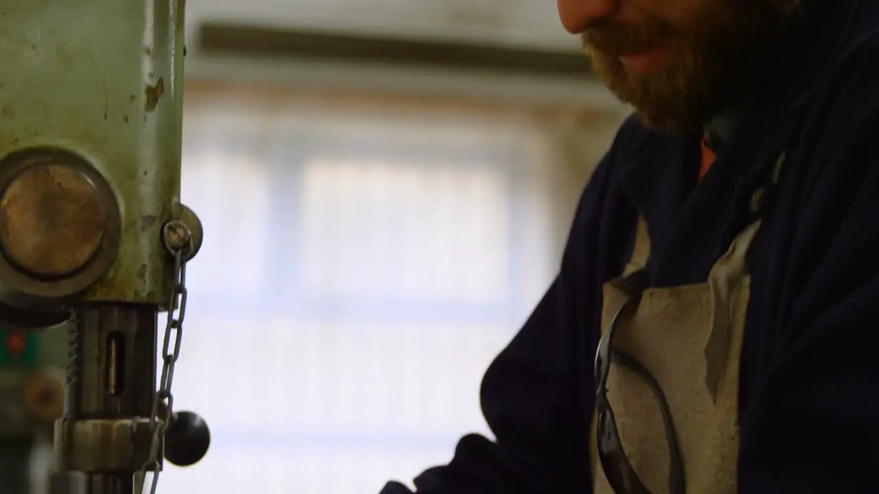 Metalsmith using drill press machine in workshop 4k