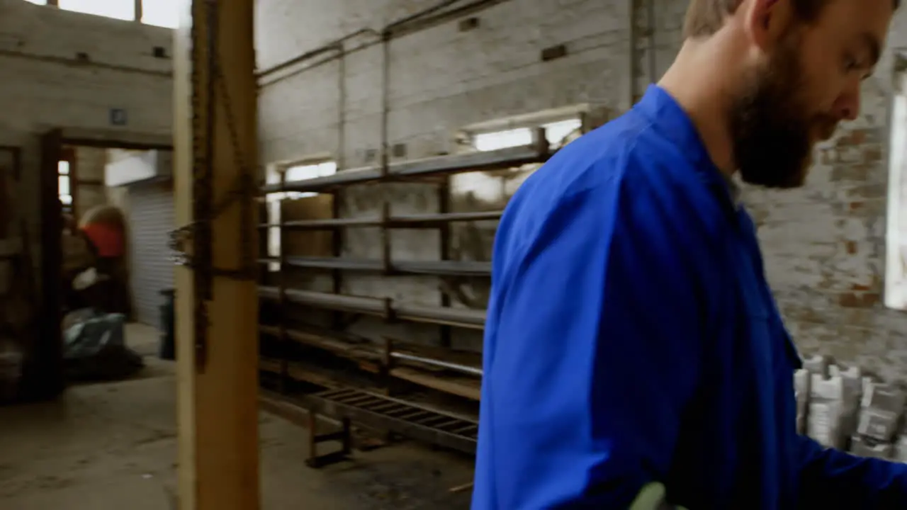 Metalsmith writing on clipboard in workshop 4k