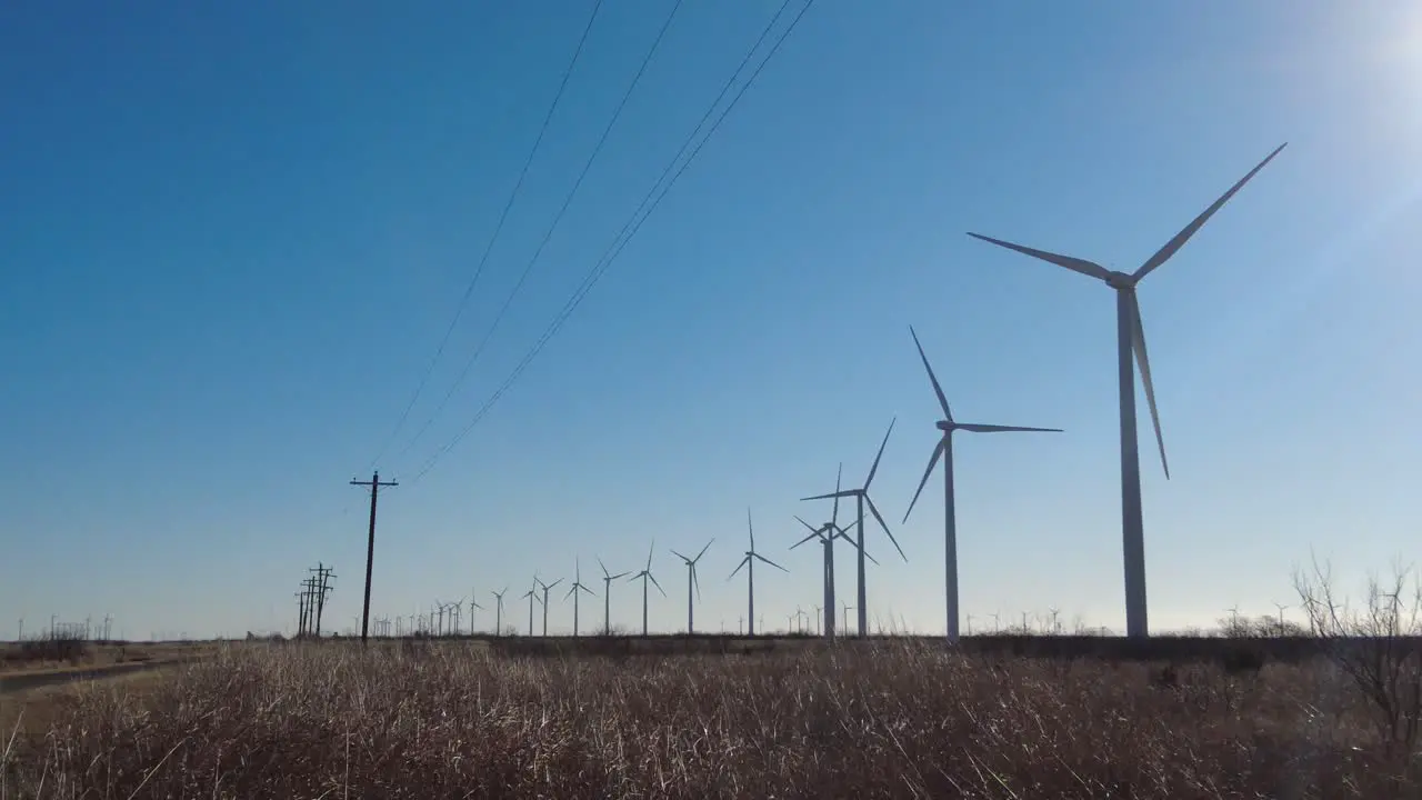 Panning across a row of wind turbines in rural west Texas