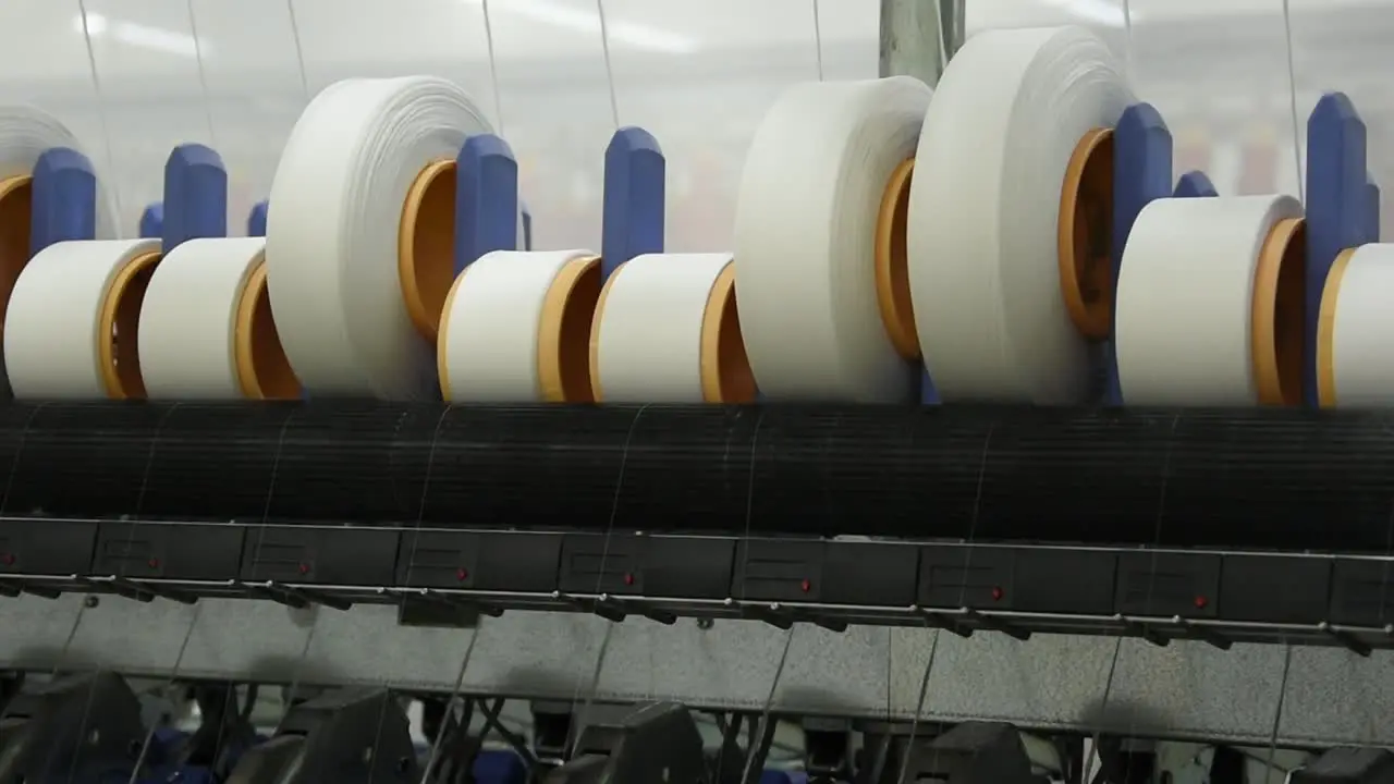 Closeup Operating Spinning Machine with White Thread Bobbins