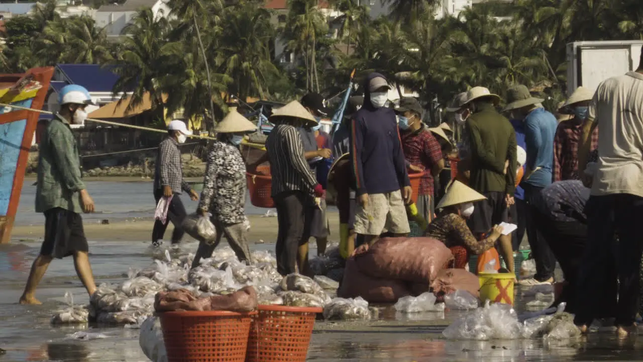 Fishermen villagers in Vietnam carry plastic bags full of fresh caught seafood