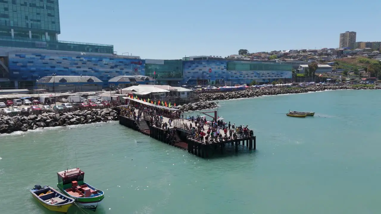 Pier With Crowds Of People Near San Antonito Port In Chile With Muelle Behind