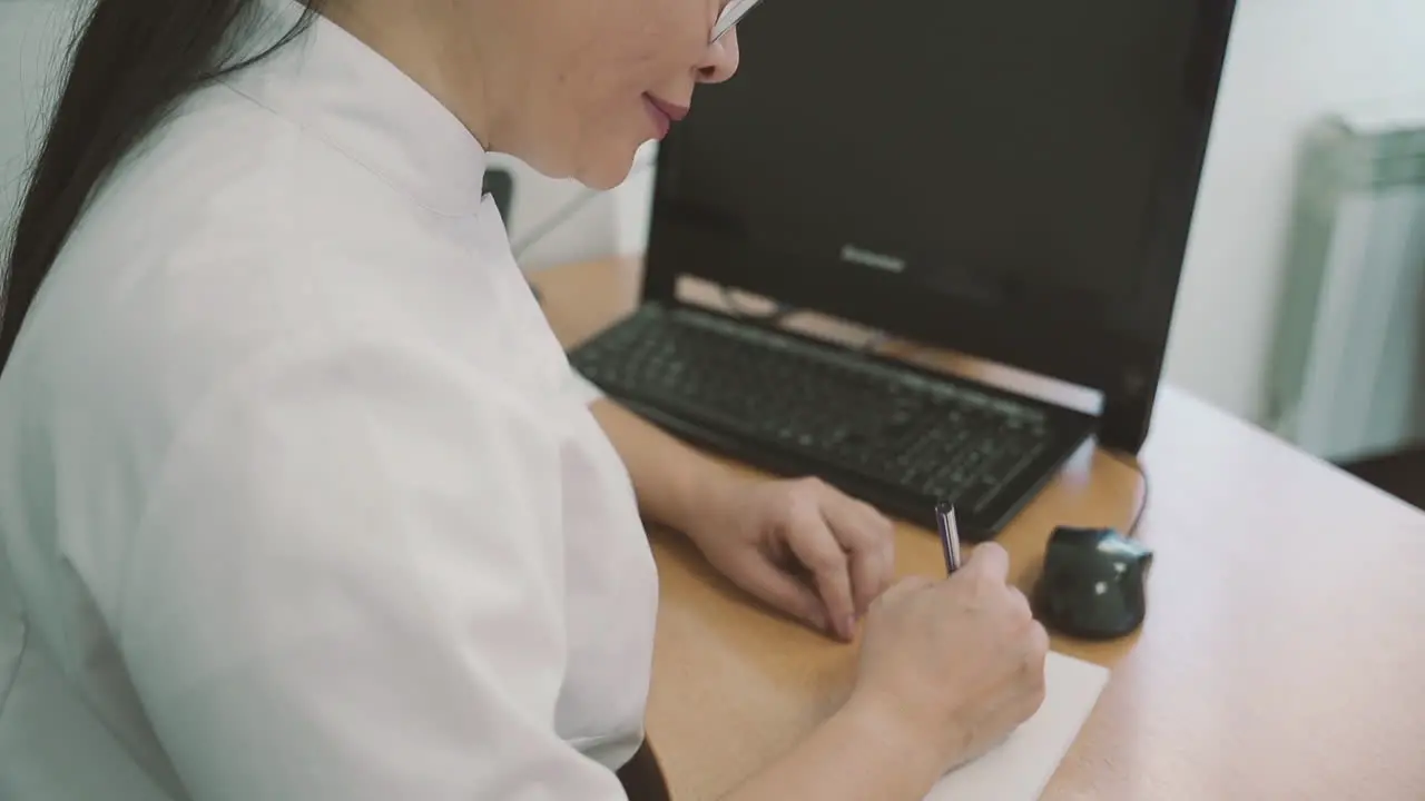 Female Doctor Writes A Prescription On A Piece Of Paper