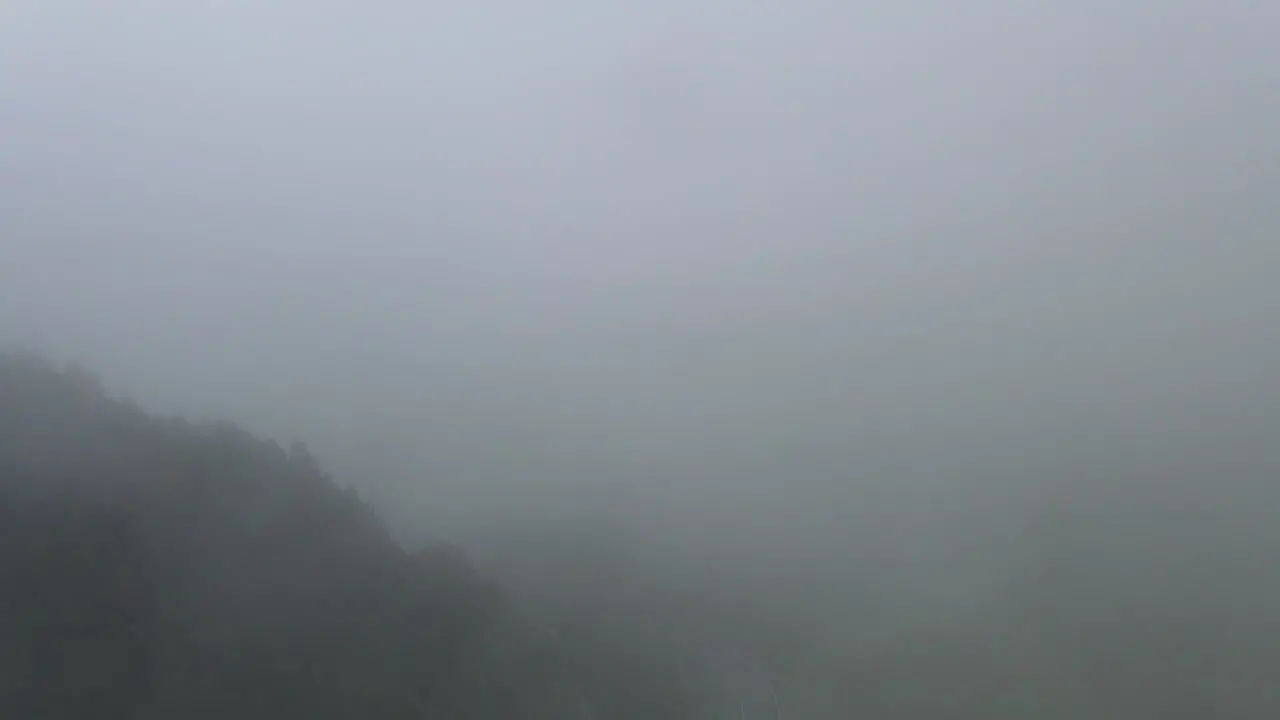 Aerial View Of A Drone Penetrating A Thick Cloud Over A Pine Forest In The Pyrenees