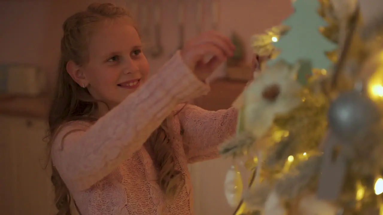 Little Girl Decorates The Christmas Tree With Ornaments