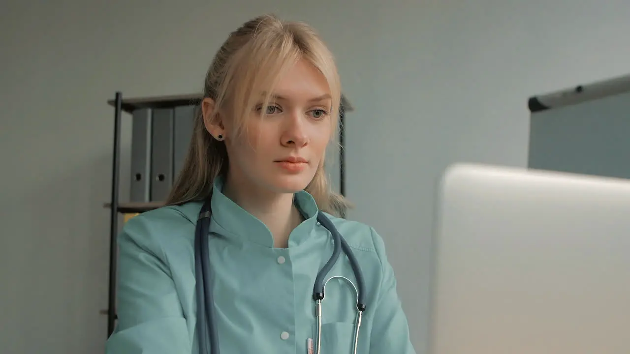 Portrait Of Young Pretty Blonde Female Nurse Care Taker Using A Computer