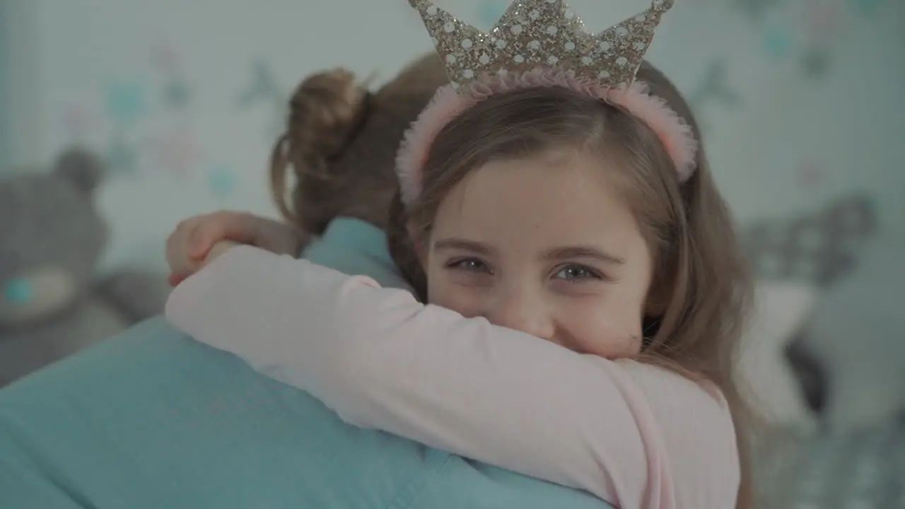 Portrait Of Little Daughter Dressed As A Princess Hugging Her Daddy At Home