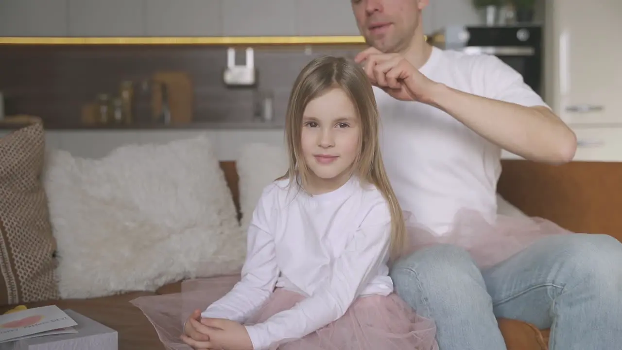 Dad Combing His Little Daughter's Hair At Home